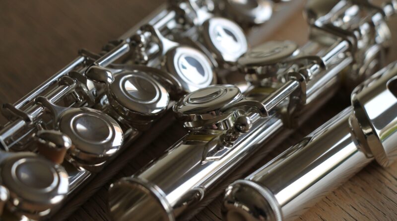 Close-up of a silver-plated flute on a wooden surface