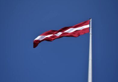 red and white state flag waving under blue sky at daytime