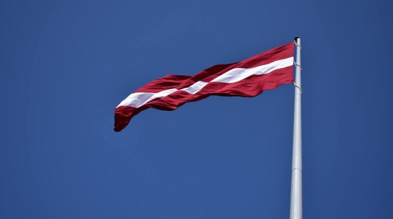 red and white state flag waving under blue sky at daytime